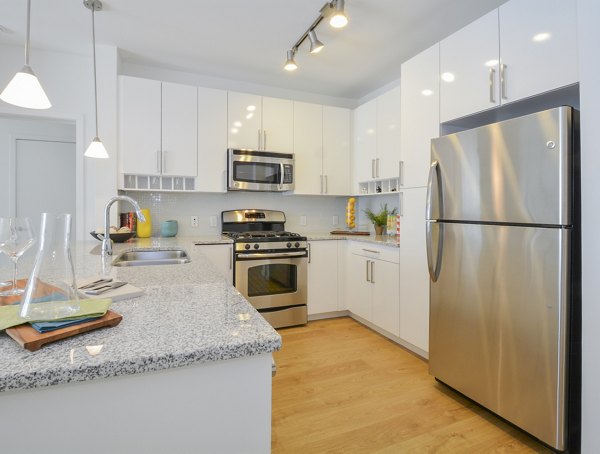 Modern kitchen with stainless steel appliances at 75 Tresser Apartments, a luxury living option by Greystar