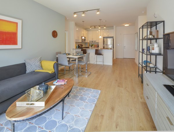 Spacious living room with modern decor and large windows in 75 Tresser Apartments