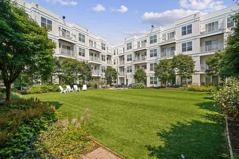 Cozy fire pit on patio next to swimming pool at 75 Tresser Apartments, offering luxury outdoor living spaces