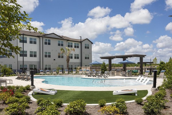 Resort-style pool at Prose Buda Apartments with lounge seating and lush landscaping