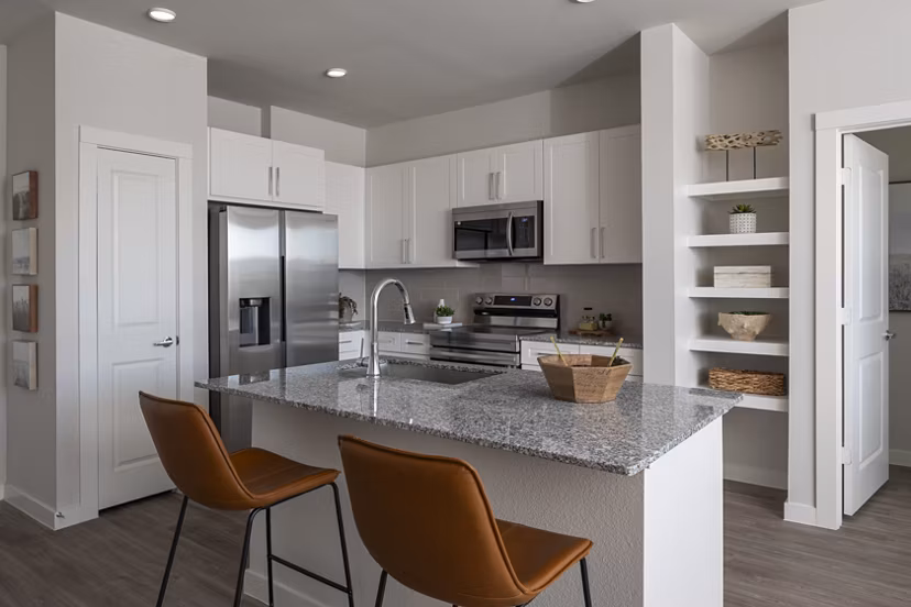 Modern kitchen with stainless steel appliances in Prose Solaire Apartments