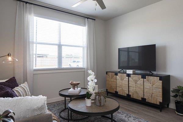 Open-concept living room with modern furnishings and natural light at Prose Solaire Apartments