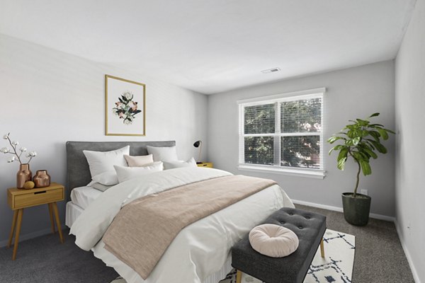 Cozy bedroom with modern decor in Luna Pointe Apartments, featuring plush bedding and ample natural light
