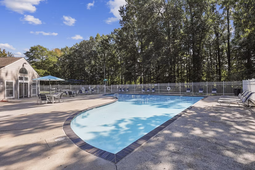 Luxurious pool with lounge chairs at Luna Pointe Apartments, ideal for relaxation in a serene residential setting