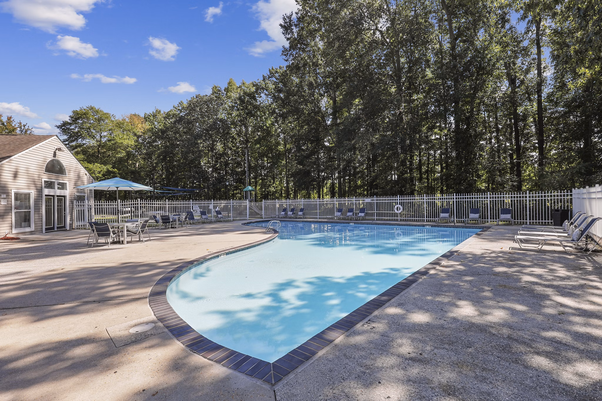 Luxurious pool with lounge chairs at Luna Pointe Apartments, ideal for relaxation in a serene residential setting