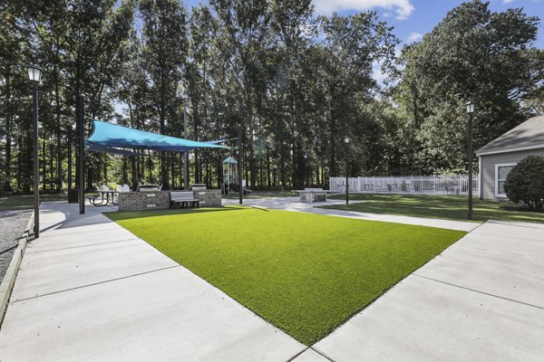 Lush green courtyard with seating areas at Luna Pointe Apartments
