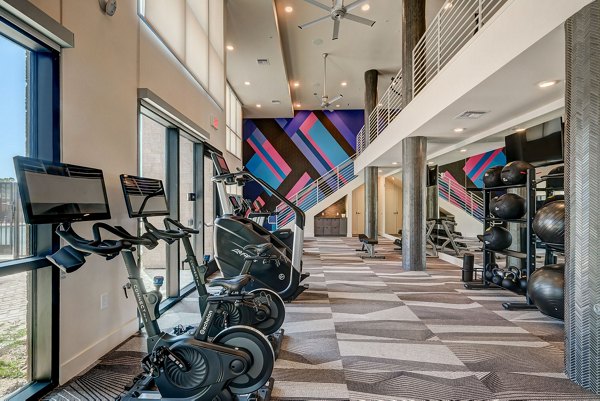 State-of-the-art fitness center featuring modern equipment and workout spaces at Encore Novo Apartments