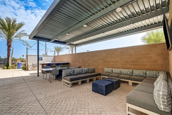 Encore Novo Apartments: Modern patio with comfortable seating and lush greenery, perfect for relaxation