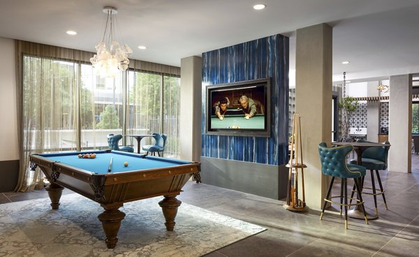 Clubhouse game room with pool tables and lounge seating at Broadstone Inkwell Apartments, offering a vibrant social space for residents to enjoy