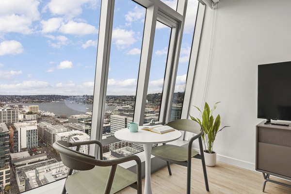 Open living area with modern decor and large windows in Skyglass Apartments