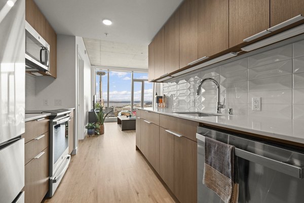 Modern kitchen with stainless steel appliances and island at Skyglass Apartments