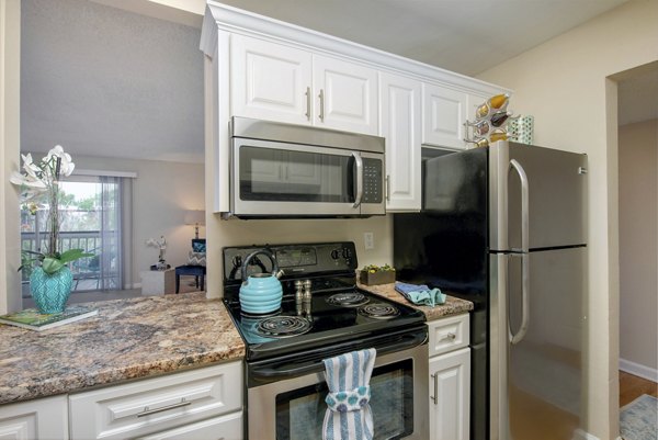 Modern kitchen with granite countertops and stainless steel appliances in Westmount at Winter Park Apartments