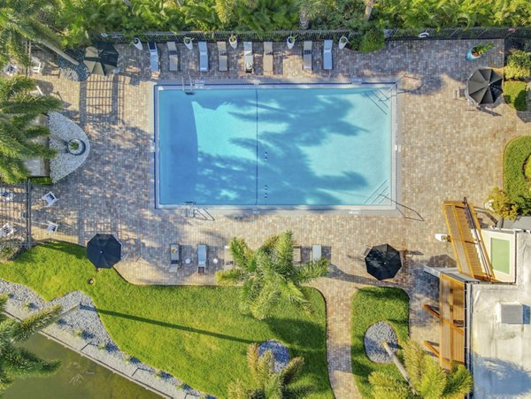 Resort-style pool with lush landscaping at Westmount at Winter Park Apartments, offering a luxurious outdoor amenity for residents