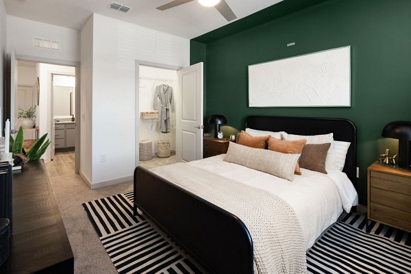 Bedroom with cozy decor and large windows at Advenir at Walker's Ridge Apartments