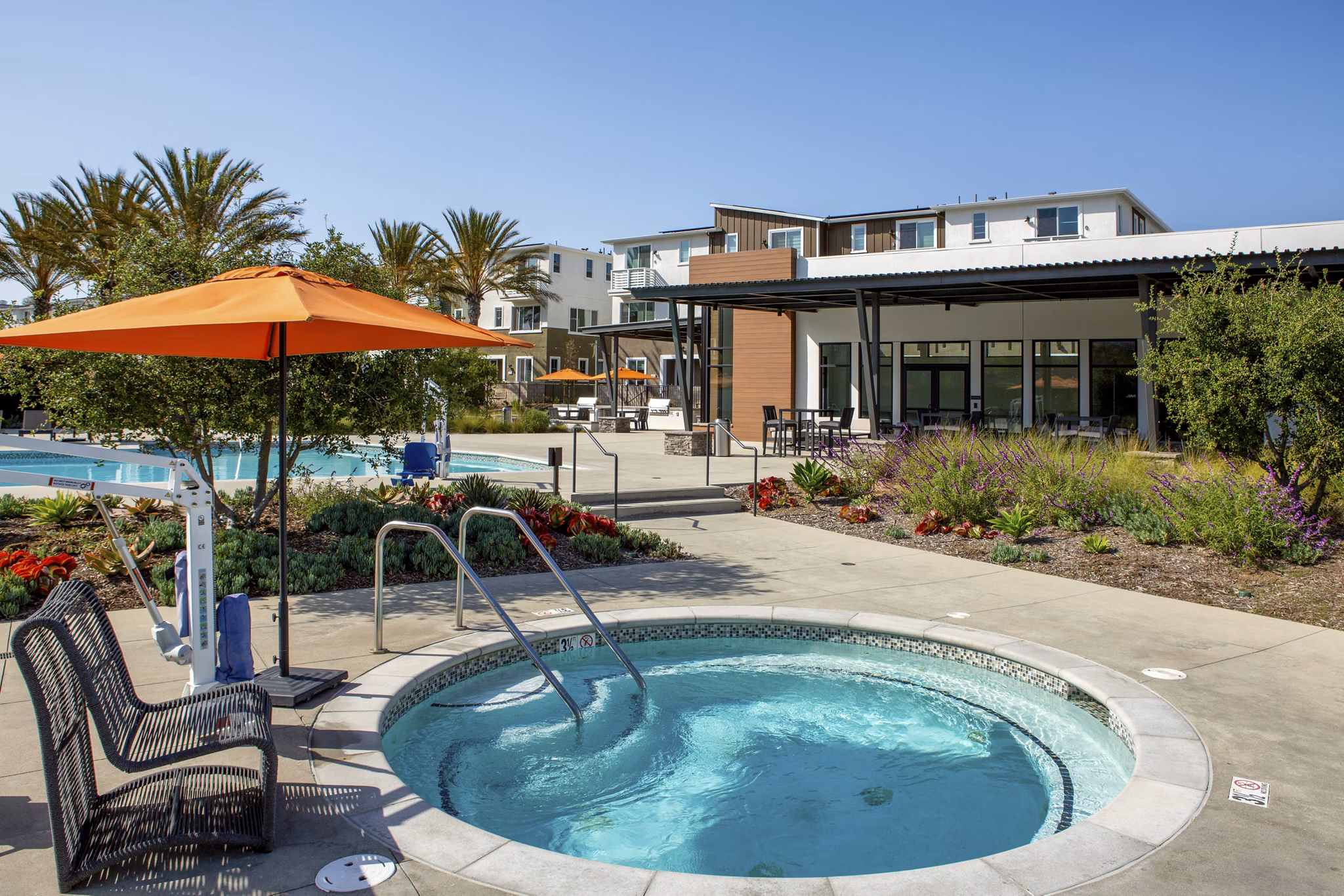 Hot tub surrounded by lush greenery at Suncrest at Ponte Vista Apartments