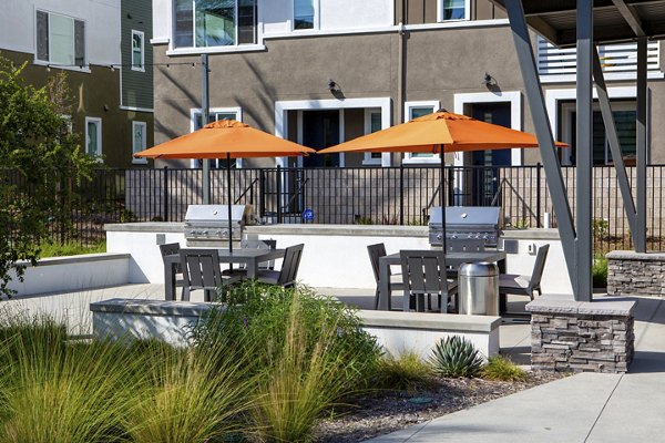 Outdoor grill area with modern seating at Suncrest at Ponte Vista Apartments