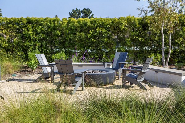 Cozy fire pit area at Suncrest at Ponte Vista Apartments with modern seating and ambient lighting, perfect for outdoor gatherings