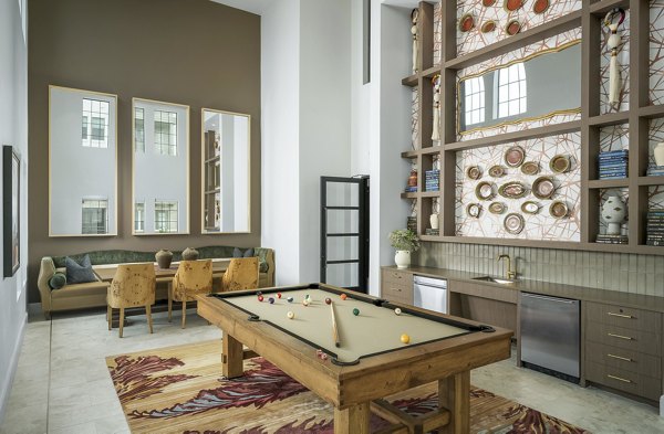 A clubhouse game room with billiards and seating at The Alyssa Apartments