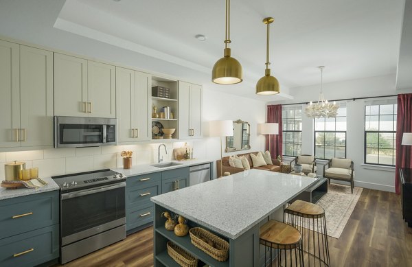 Kitchen featuring modern appliances and sleek countertops at The Alyssa Apartments