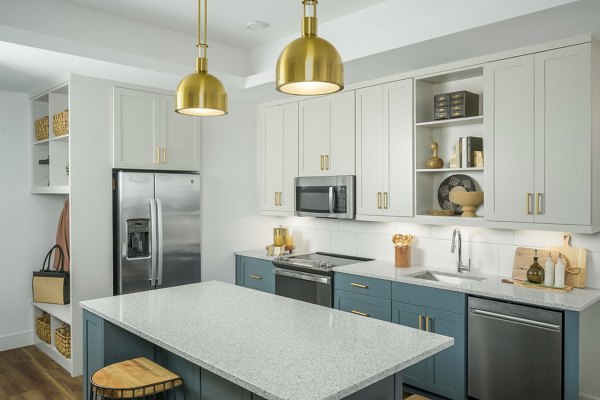 Elegant kitchen with modern appliances and marble countertops in The Alyssa Apartments