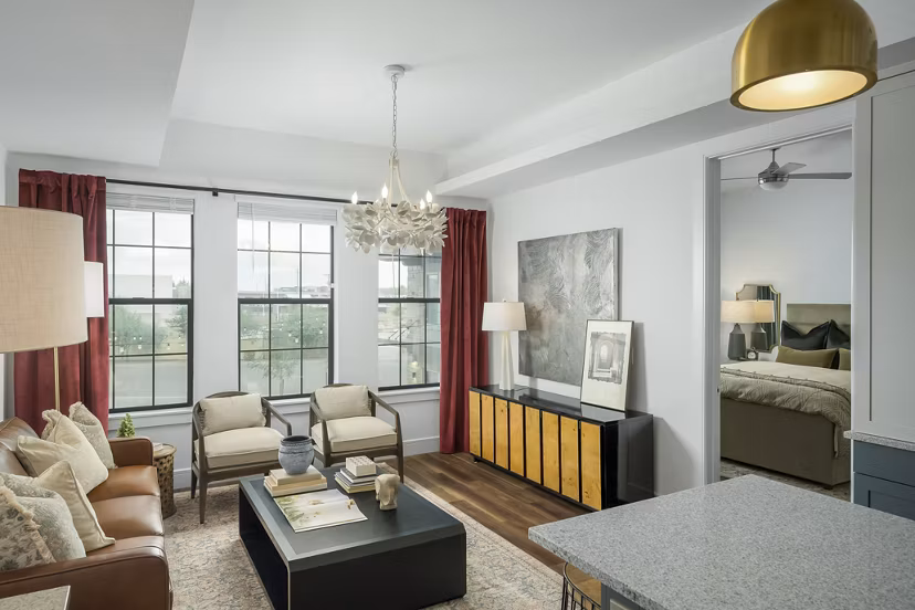 Spacious living room featuring modern dÃ©cor and large windows in The Alyssa Apartments Perfect for luxury living
