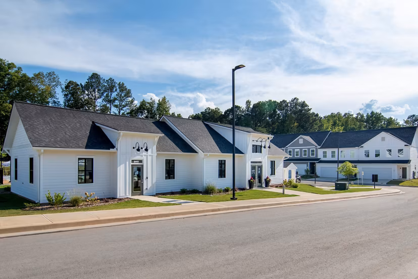 Summerwell Parkway Village Apartments: Modern building with lush greenery