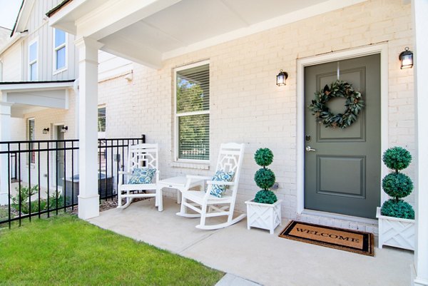 Patio with modern furnishings and lush greenery at Summerwell Parkway Village Apartments