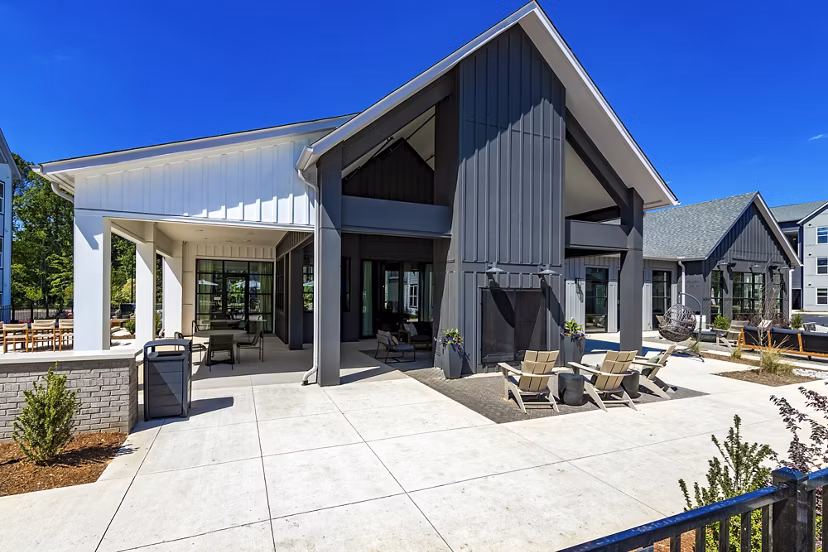 Patio with seating and lush greenery at Milo Apartments, offering a relaxing outdoor space