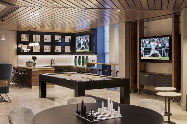 Clubhouse game room with pool table and lounge seating at The Octagon Apartments, luxury living offered by Greystar