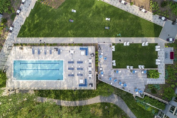 Sleek outdoor pool with lounge chairs at The Octagon Apartments, offering luxury living in a serene setting