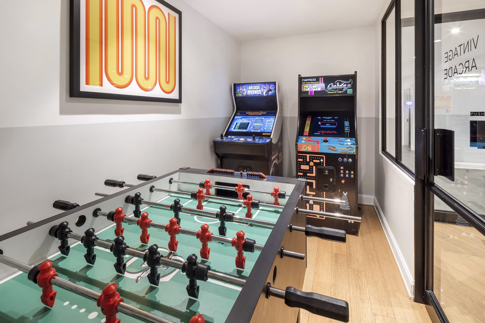 Game room with pool table and arcade games at Oriana Apartments, offering luxury entertainment spaces for residents