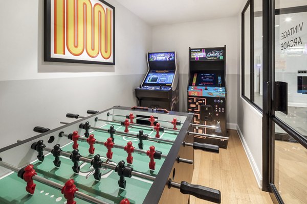 Game room with pool table and arcade games at Oriana Apartments, offering luxury entertainment spaces for residents
