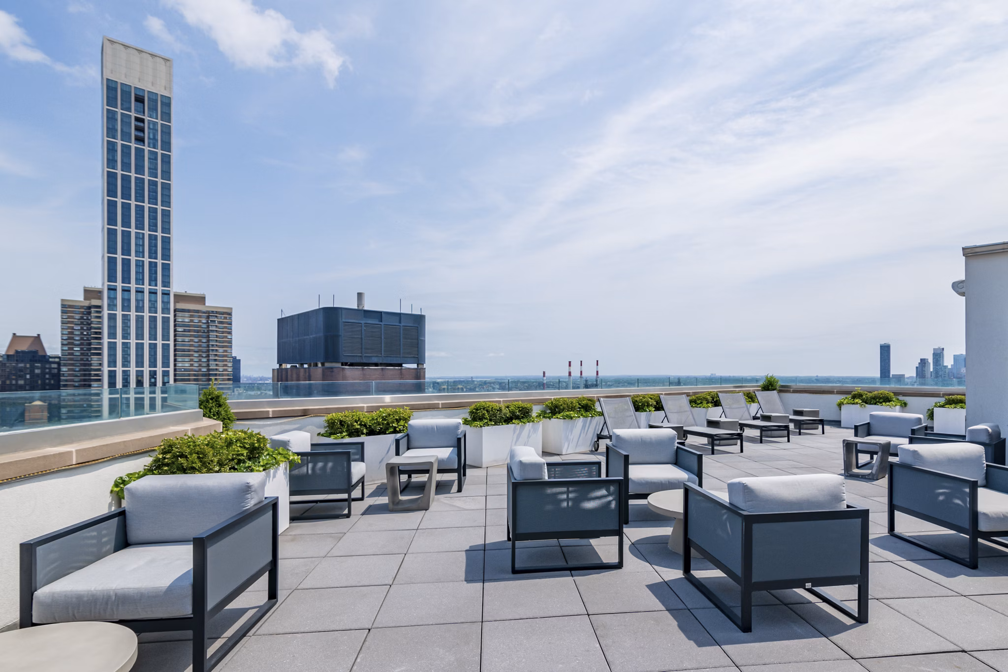 Rooftop deck with lounge seating at Oriana Apartments offering panoramic city views