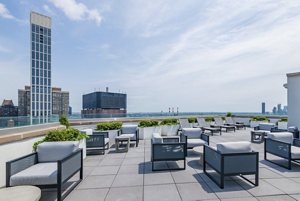 Rooftop deck with lounge seating at Oriana Apartments offering panoramic city views