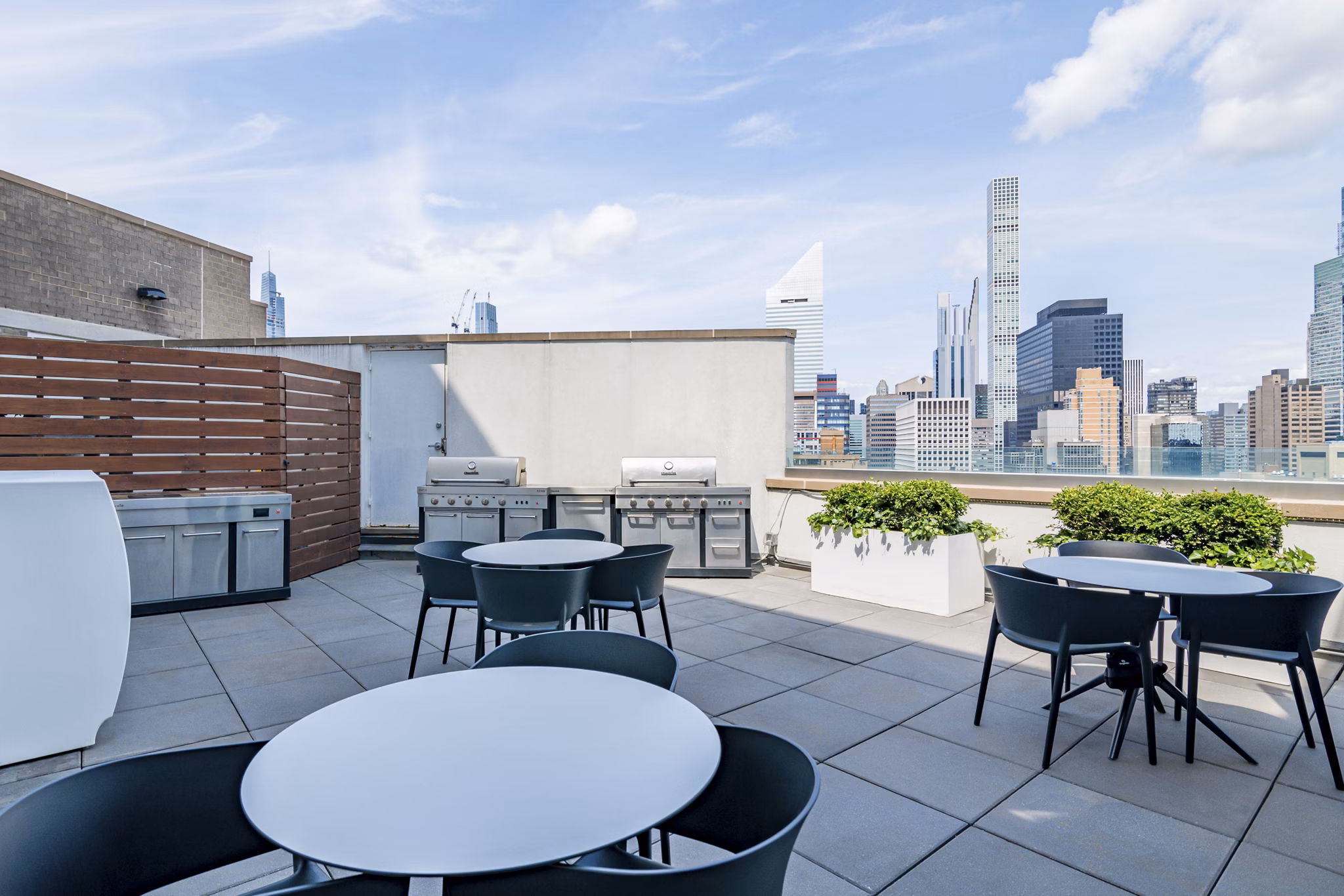 Outdoor grill area with seating at Oriana Apartments, a luxury apartment community by Greystar Perfect for social gatherings and entertaining