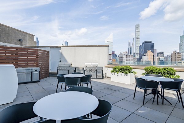 Outdoor grill area with seating at Oriana Apartments, a luxury apartment community by Greystar Perfect for social gatherings and entertaining