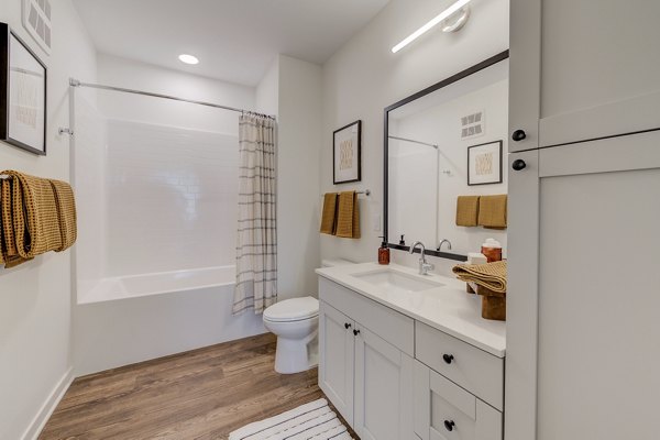 Elegant bathroom with marble countertops and sleek fixtures at The James Apartments