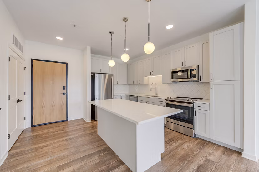 Modern kitchen with stainless steel appliances and breakfast bar at The James Apartments luxury living space