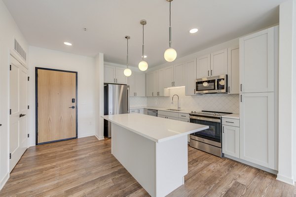 Modern kitchen with stainless steel appliances and breakfast bar at The James Apartments luxury living space