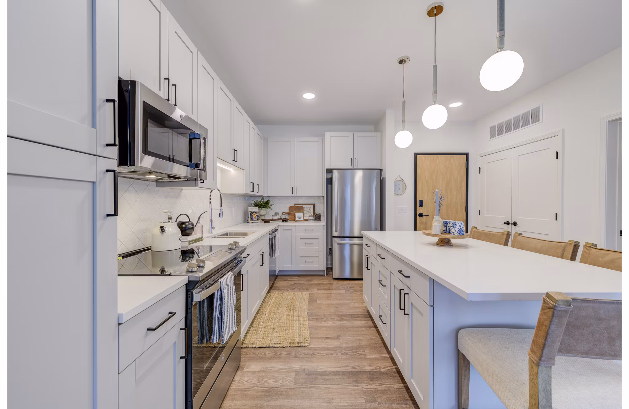 Kitchens featuring granite countertops and stainless steel appliances at The James Apartments
