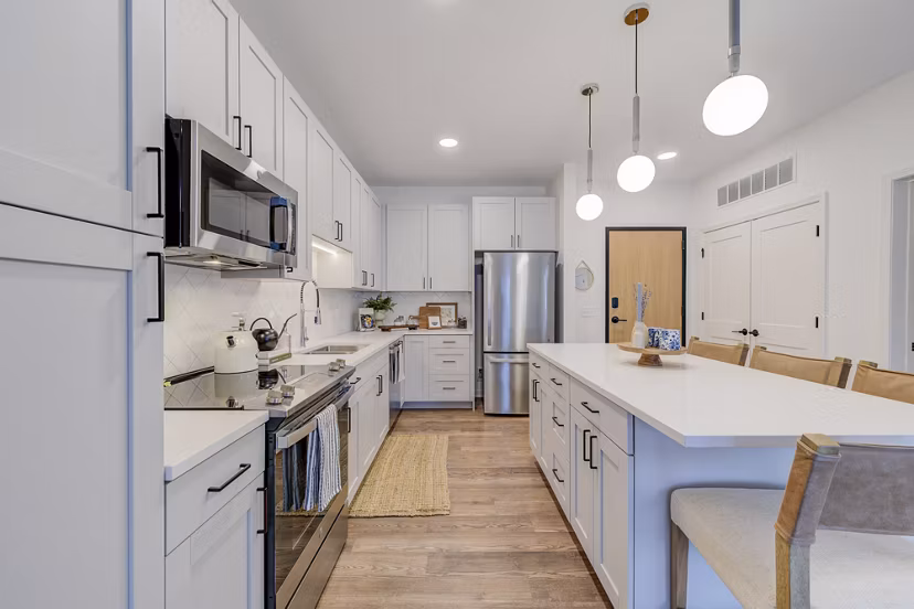 Kitchens featuring granite countertops and stainless steel appliances at The James Apartments
