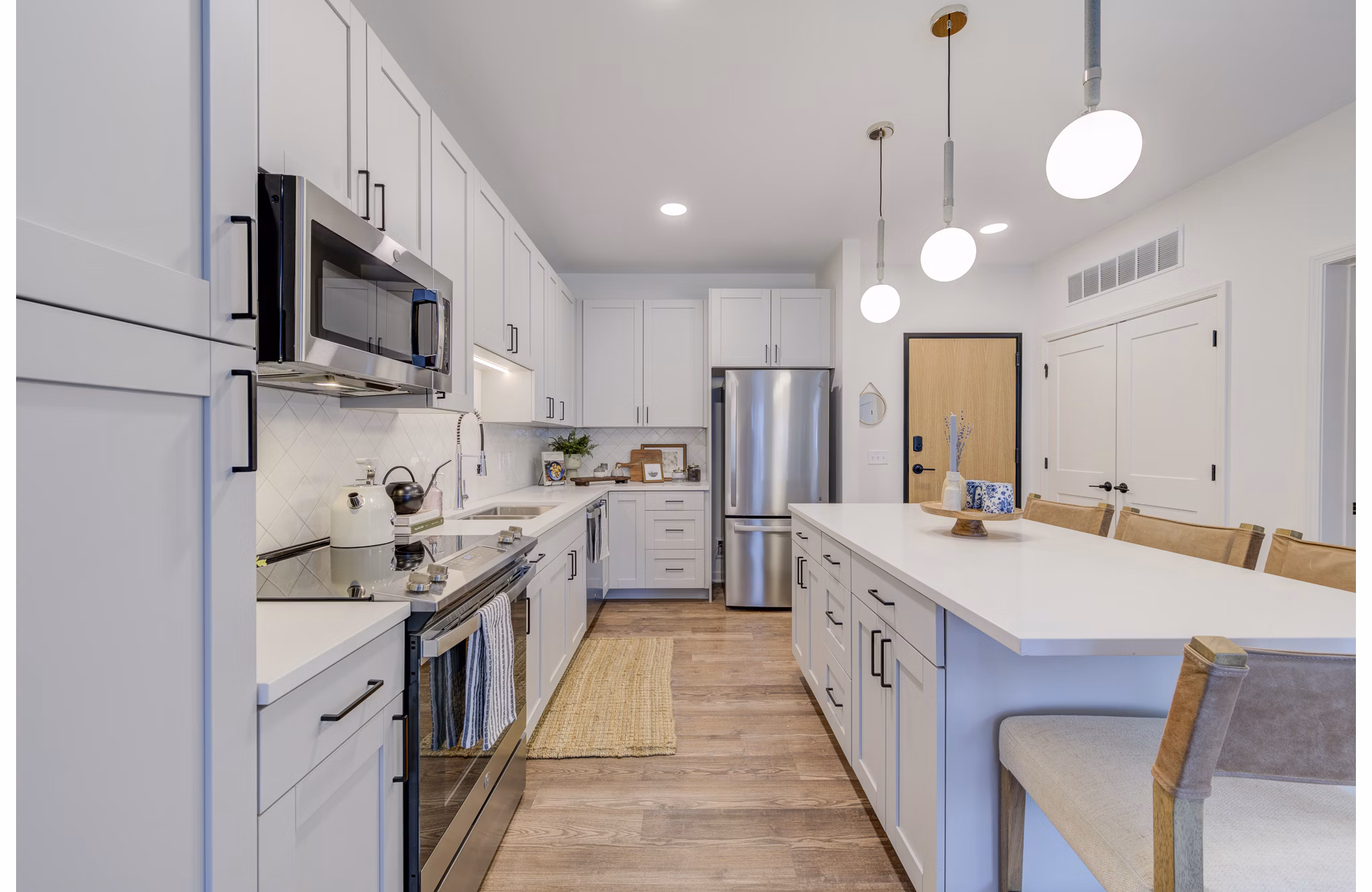 Kitchens featuring granite countertops and stainless steel appliances at The James Apartments