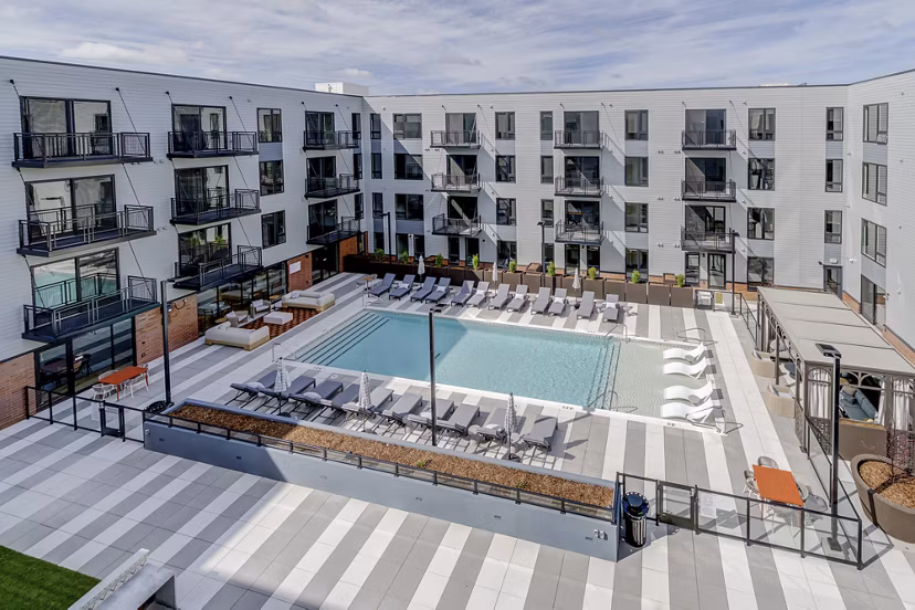 Resort-style pool with lounge chairs at The James Apartments, ideal for luxury living and relaxation