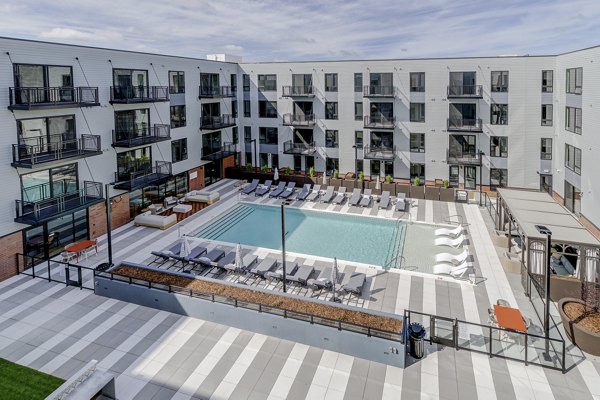 Resort-style pool with lounge chairs at The James Apartments, ideal for luxury living and relaxation