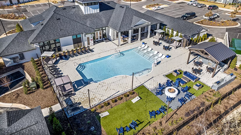 Resort-style pool area at Arlow at Blue Ridge Apartments with lounge chairs and lush landscaping