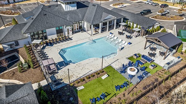 Resort-style pool area at Arlow at Blue Ridge Apartments with lounge chairs and lush landscaping
