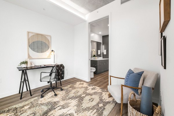 Modern bedroom/home office with ample natural light at Willamette Tower Apartments, perfect for luxury living and productivity in Portland