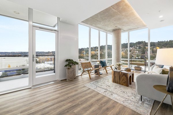 Modern living room with large windows and city views at Willamette Tower Apartments