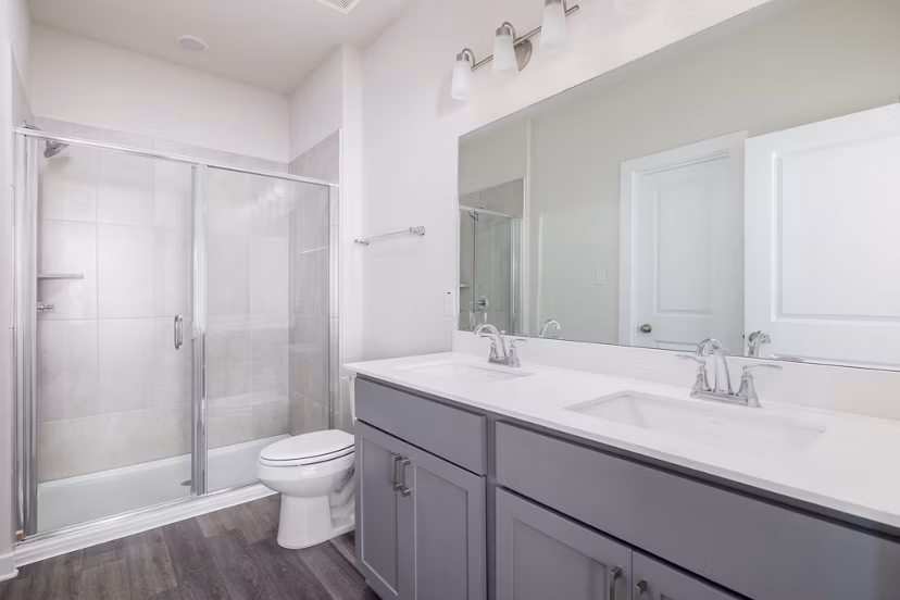 Modern bathroom with large vanity and sleek fixtures at Caso University Heights Apartments