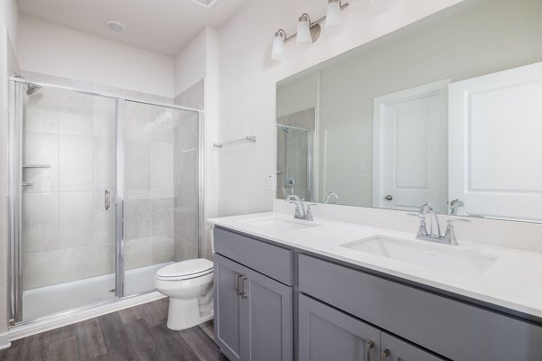 Modern bathroom with large vanity and sleek fixtures at Caso University Heights Apartments